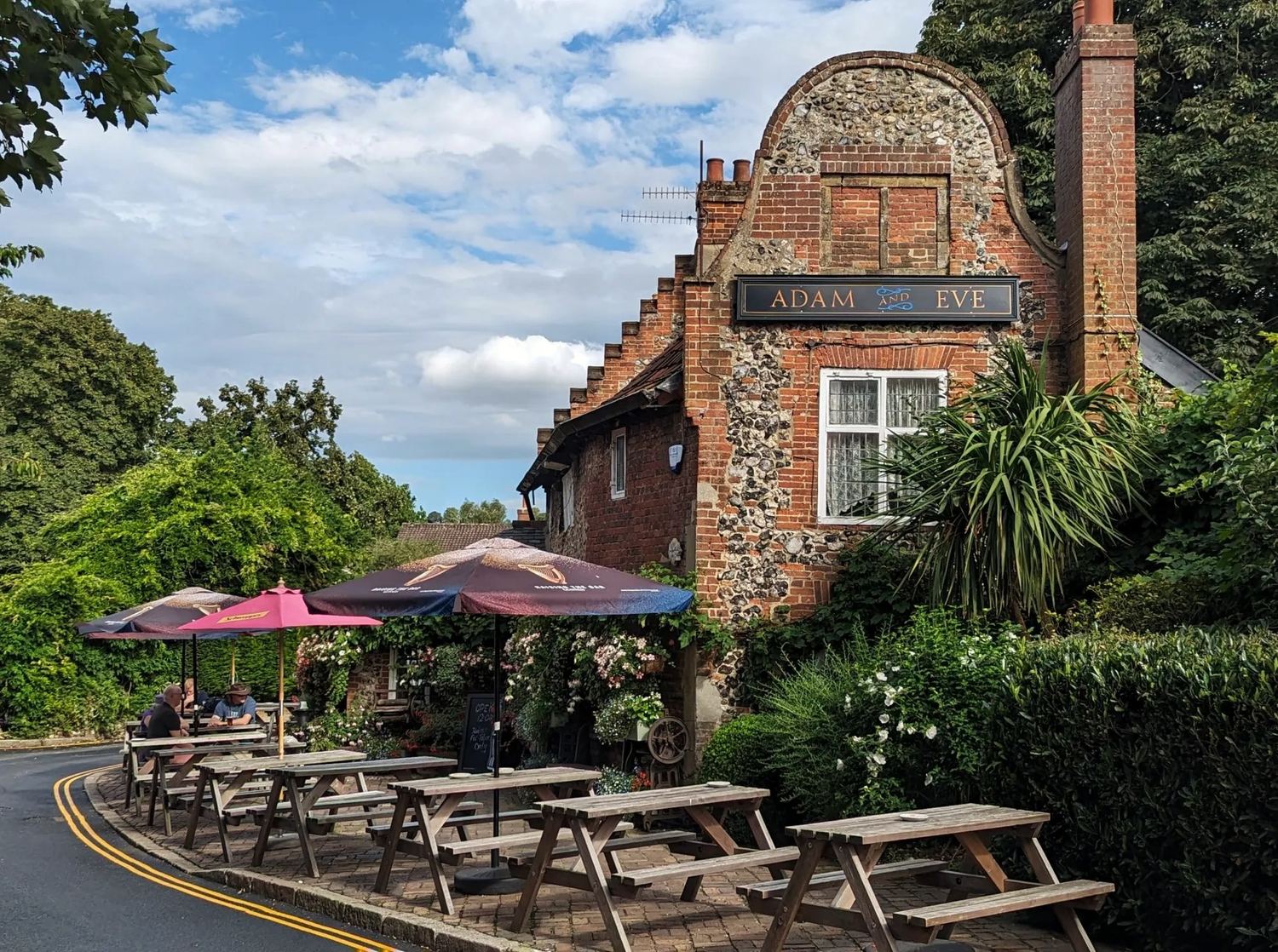 The Adam and Eve in Norwich, its Dutch gable and flint frontage above picnic tables set out on the pavement