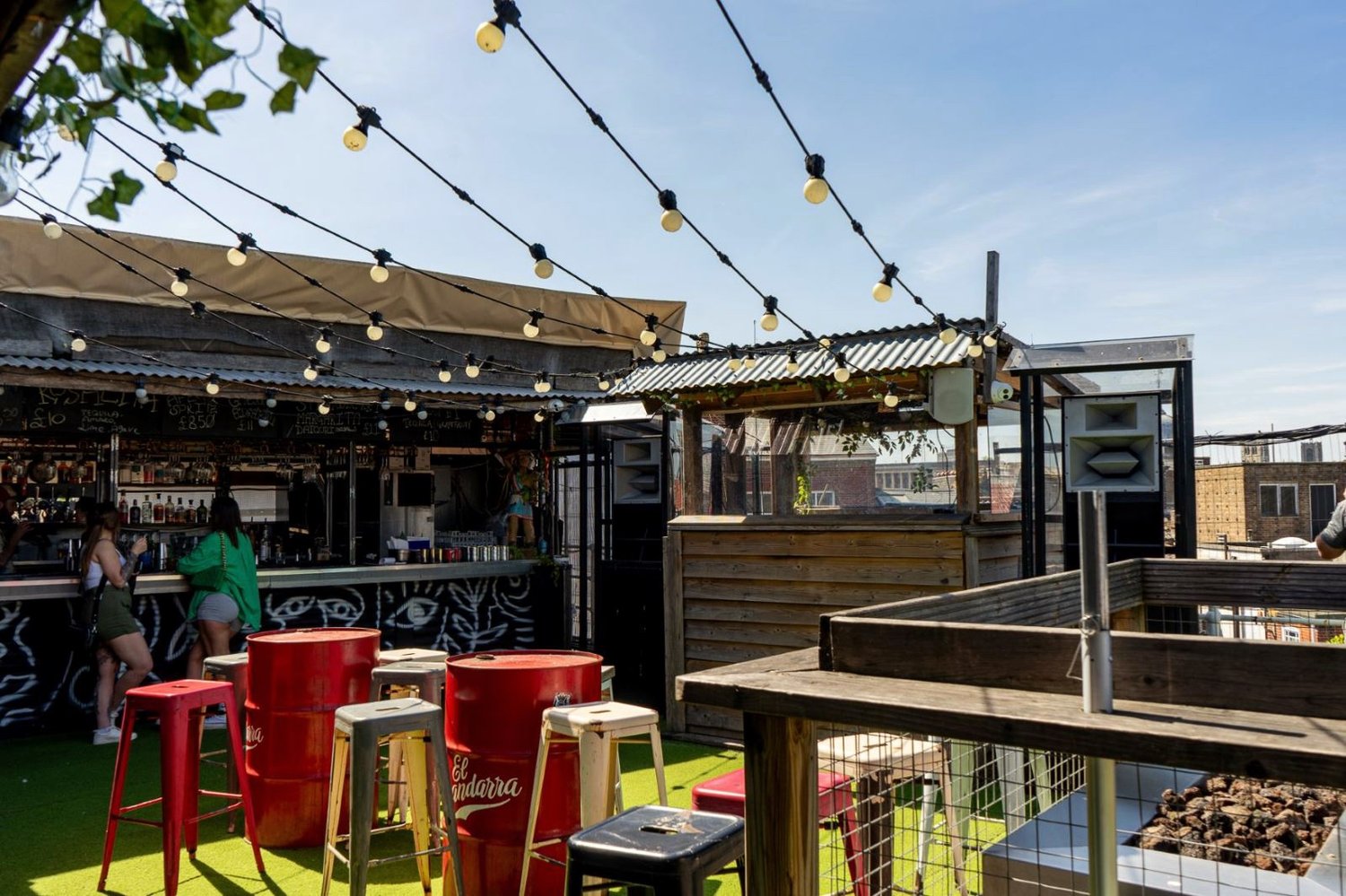The rooftop bar at Gonzo's in Norwich, festoon lights strung above stools and oil-drum tables, with a fire pit to one side