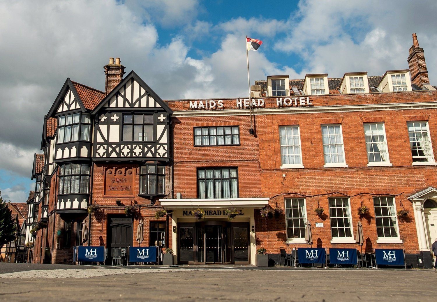 The Maids Head Hotel on Tombland in Norwich, its mock Tudor frontage and red brick facade seen from the square