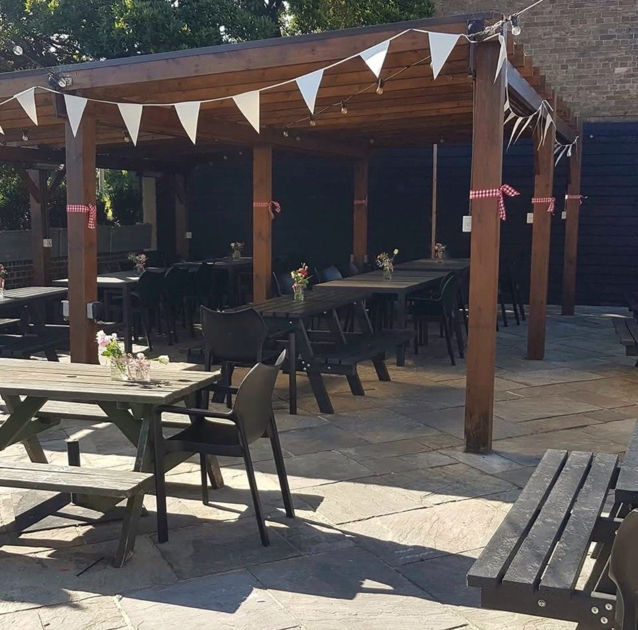 The covered terrace at Temple Bar in Norwich, bunting and festoon lights strung across long tables