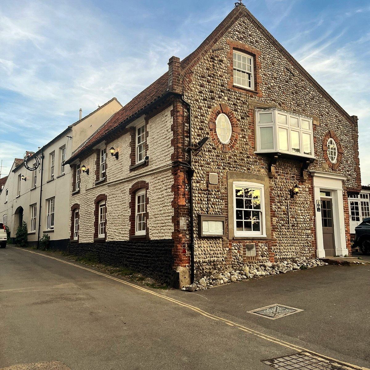 The flint and brick corner frontage of the White Horse pub on the high street at Blakeney